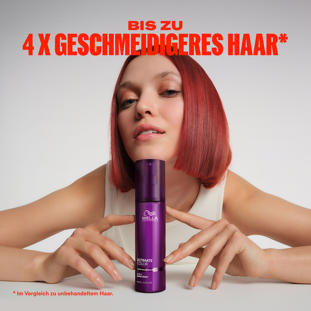 frau-mit-rotem-bob-haarschnitt-haelt-lila-wella-step-2-der-serie-ultimate-color-shine-spray-flasche-mit-werbetext-bis-zu-4x-geschmeidigeres-haar-im-bild