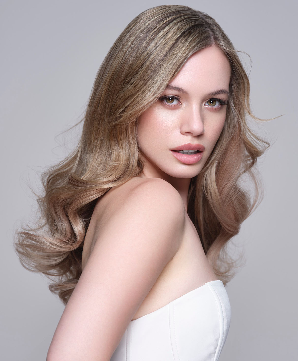 asp-kitoko-imagebild-frau-mit-welligem-blondem-haar-und-weissem-top