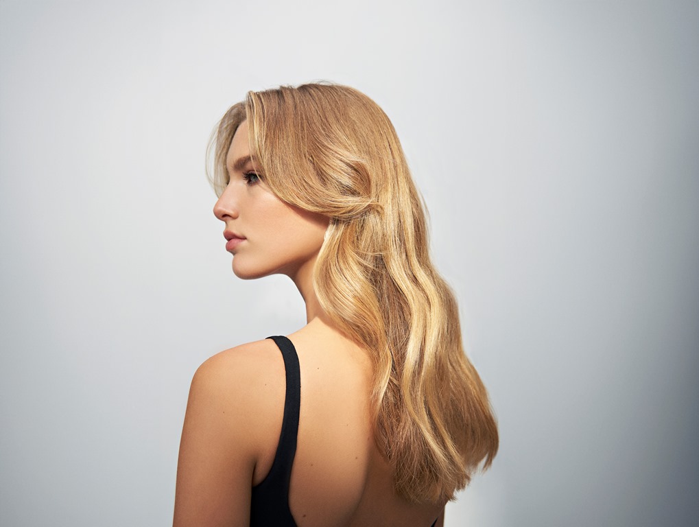 frau-mit-langen-blonden-haaren-seitliche-ansicht-gestylz-mit-ghd-duet-blowdry-heissluftbuerste