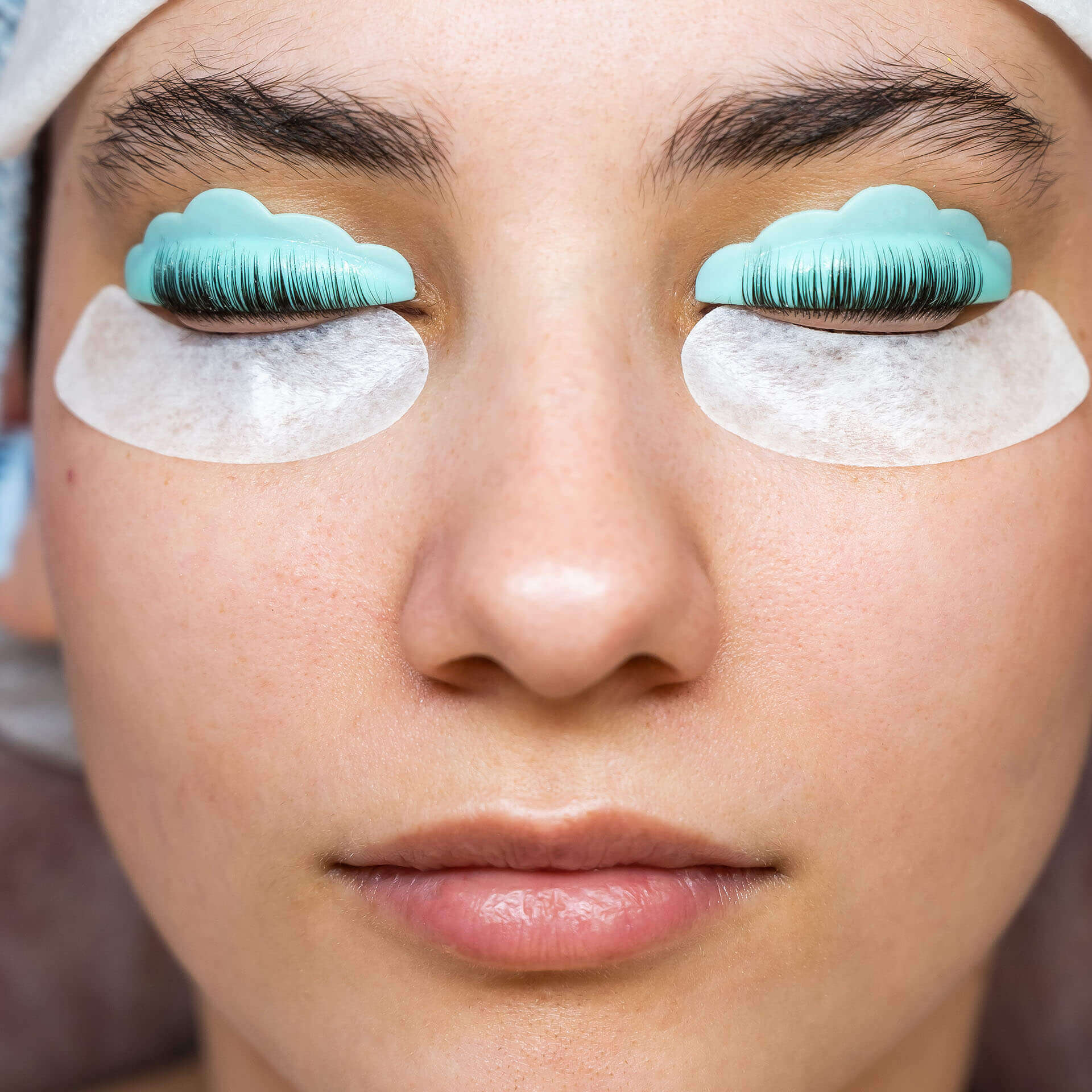 frau-mit-geschlossenen-augen-bei-wimpernlifting-behandlung-mit-silikonpads-und-schutzpads-unter-den-augen