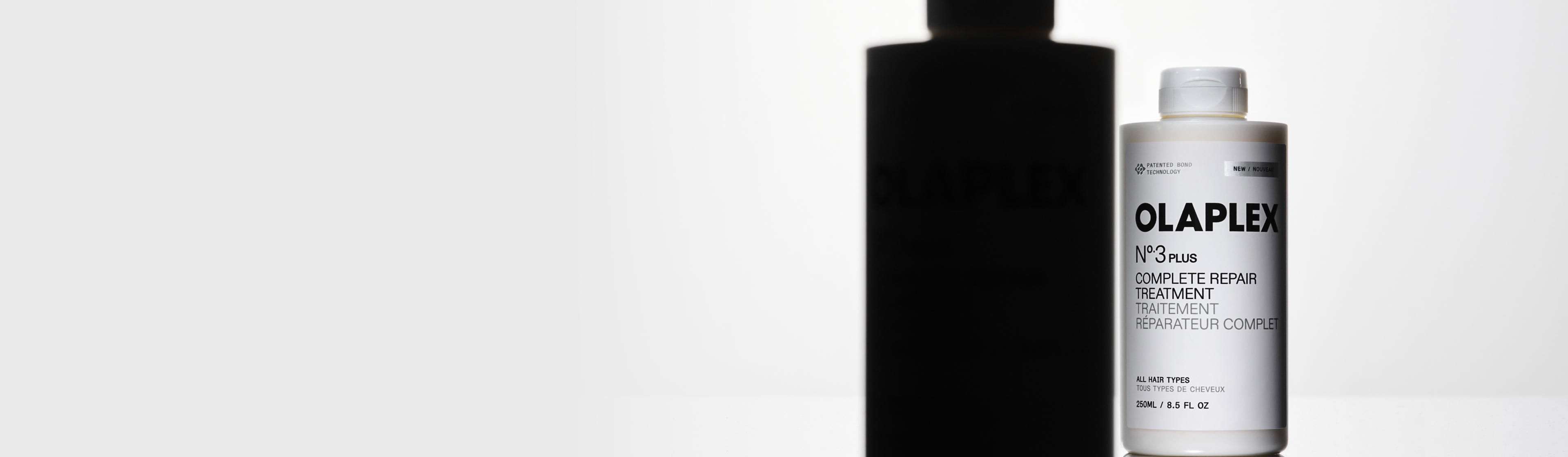 flasche-des-olaplex-no3-plus-complete-repair-treatment-pre-shampoos-fuer-geschaedigtes-haar-vor-unscharfem-hintergrund