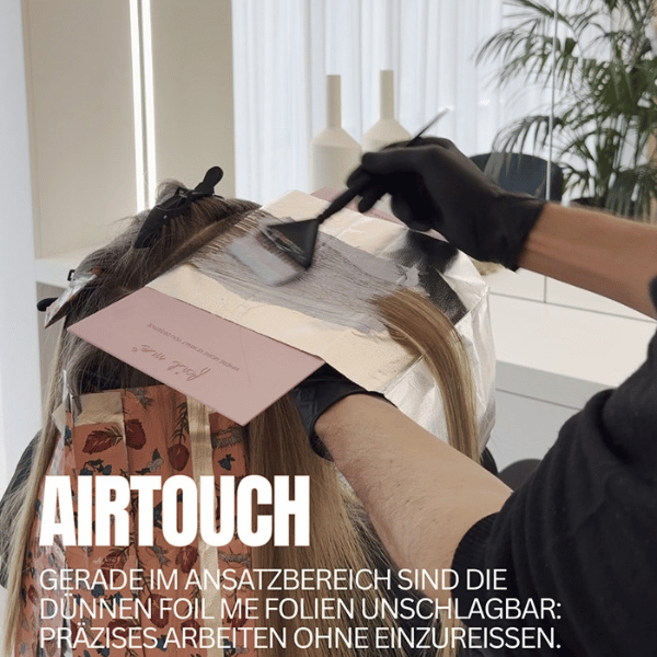 friseur-bei-einer-airtouch-coloration-mit-rosa-foil-me-straehnenfolie
