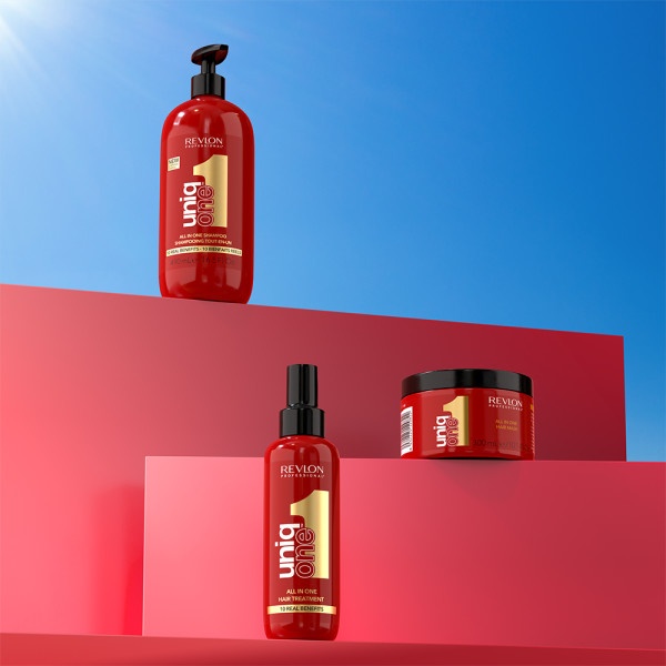 revlon-uniq-one-produkte-mit-roten-flaschen-und-dose-auf-farbigen-podesten-mit-shampoo-treatment-und-haarmaske